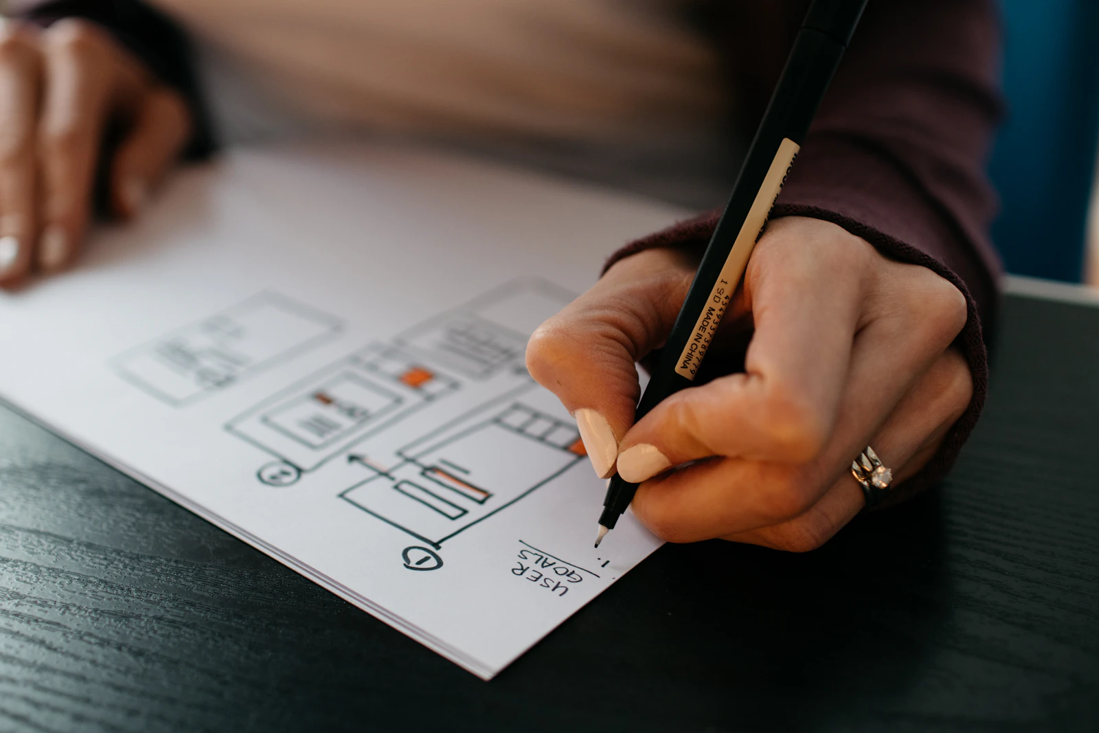Hands sketching website wireframes on paper